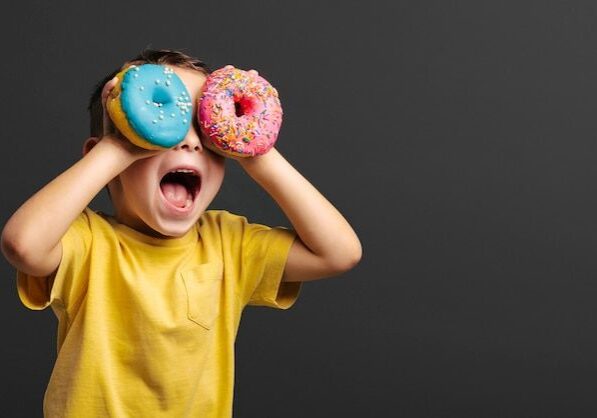 Premium Photo | Happy cute boy is having fun played with donuts Premium Photo | Happy cute boy is having fun played with donuts